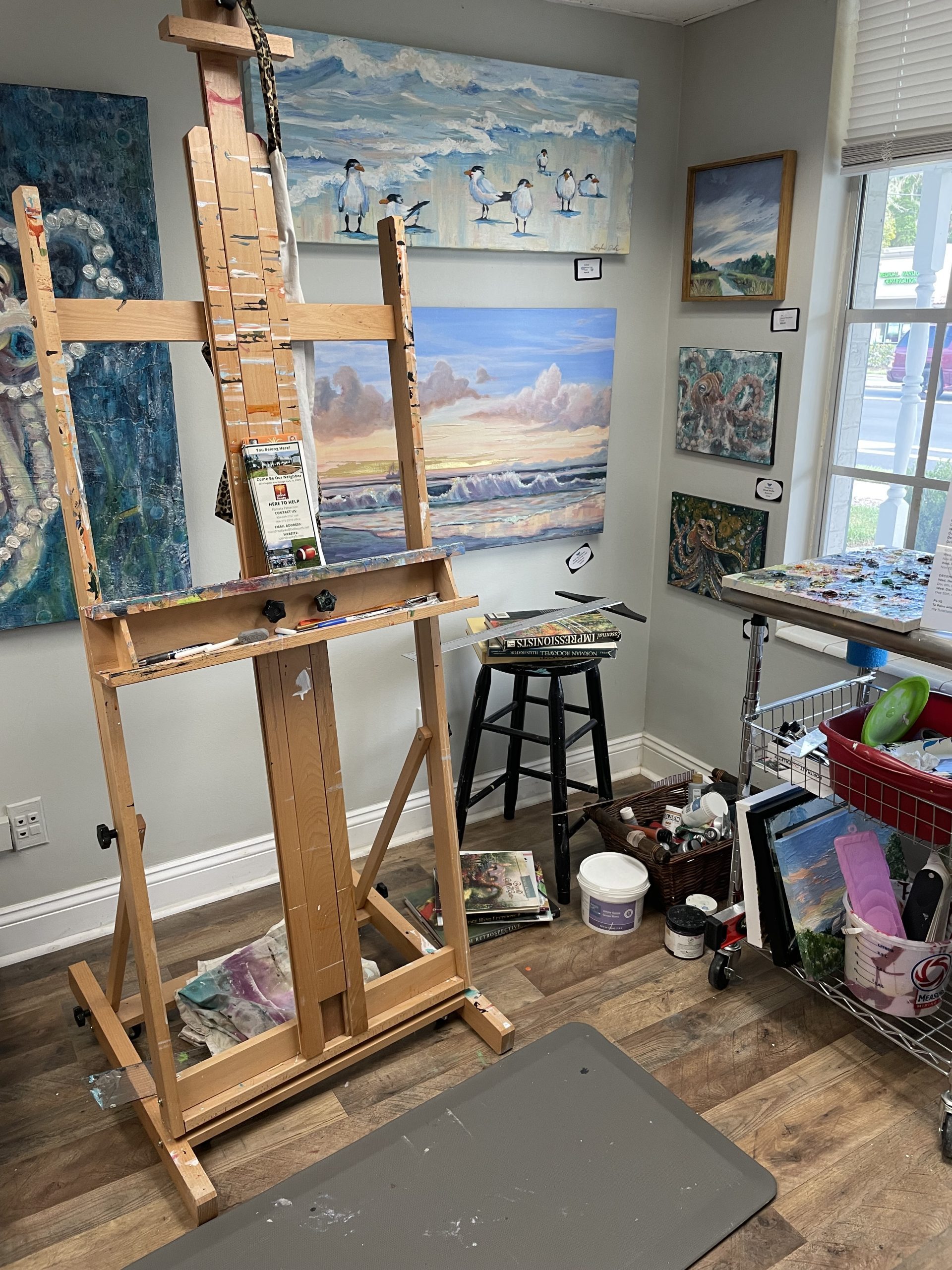 Photo of an art studio with a art easel and canvas paintings
