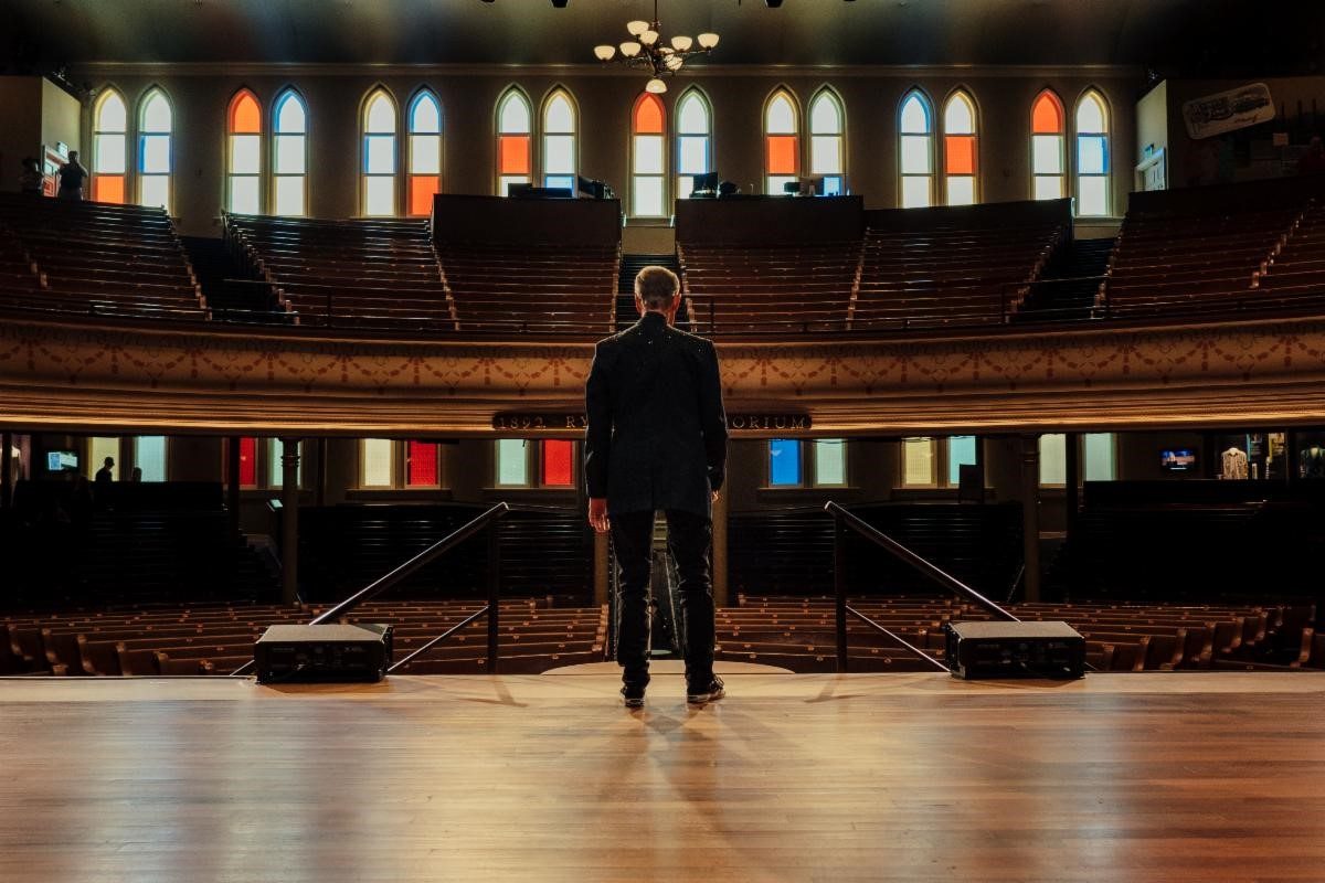 Man facing empty auditorium.