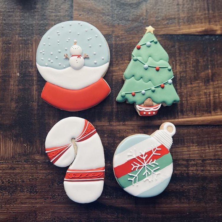Four christmas cookies include snowglobe, christmas tree, candy cane, and ornament designs