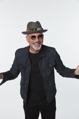 Photo of Howie Mandel dresses in all black posed in front of a white background