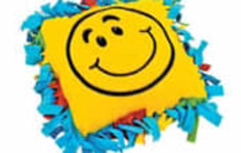 Picture of a tie yellow tie pillow with a smiley face.