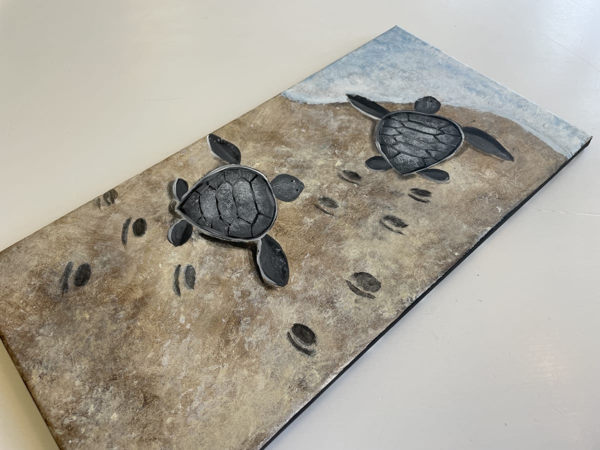 Picture of a painting of sea turtles at the beach.