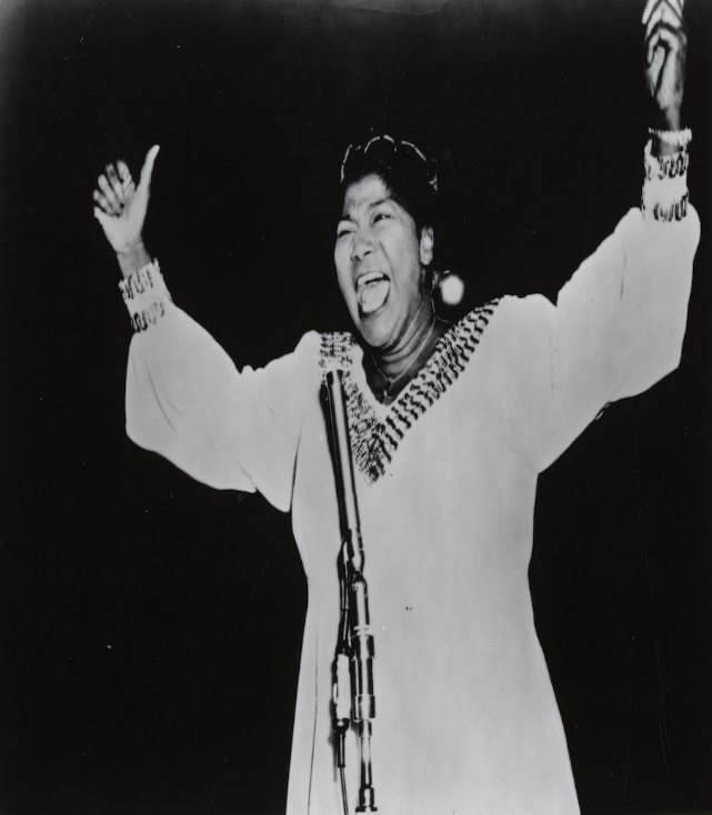 Historical black and white photo of a woman singing.