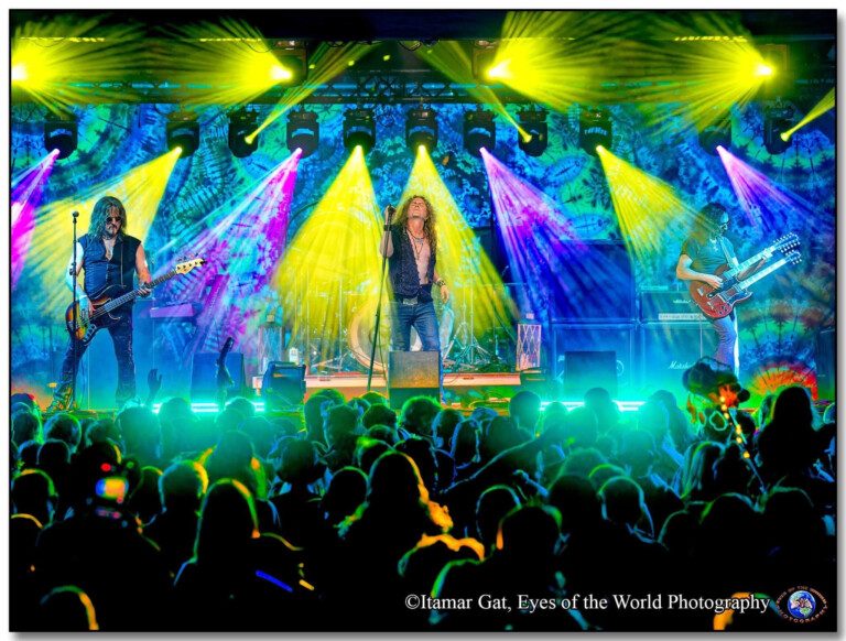 Band members on stage with multi-colored lights behind them.