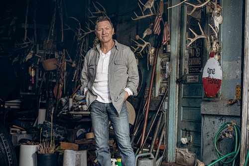 Photo of Country music singer Craig Morgan standing in a garage.