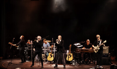 Bandmates performing on stage.